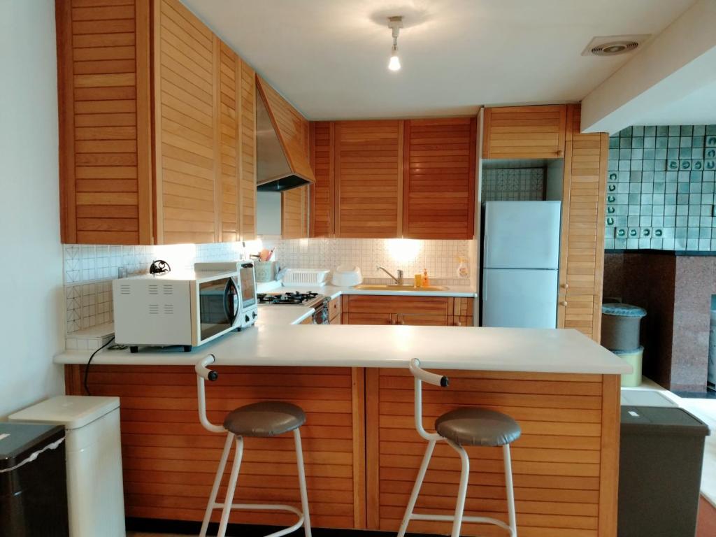 小樽市にあるBay View House - Vacation STAY 17471のキッチン(電子レンジ付きのカウンターのスツール2つ付)