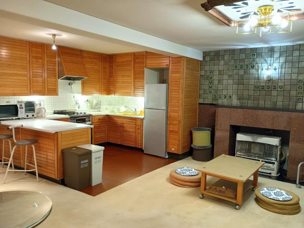 小樽市にあるBay View House - Vacation STAY 17471の木製キャビネットと冷蔵庫付きの広いキッチンが備わります。