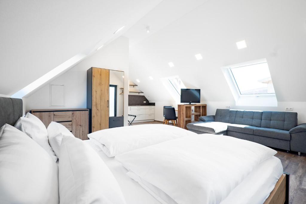 a bedroom with a white bed and a couch at Landhotel Kirchberg - Hotel Garni in Kirchberg an der Jagst
