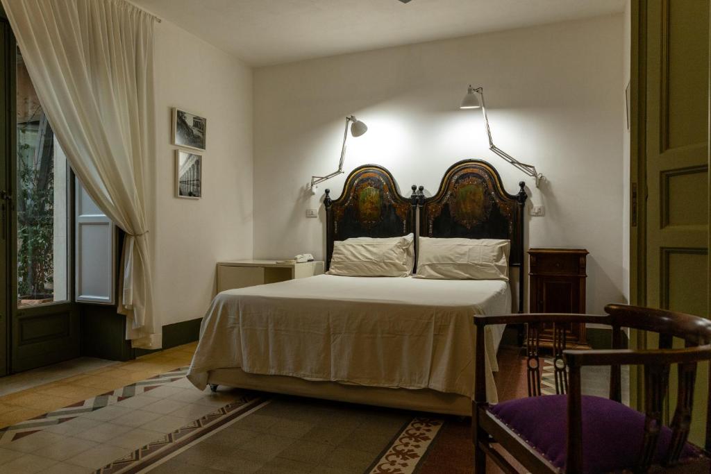 una camera da letto con un letto grande con testiera in legno di La Moresca Hotel a Marina di Ragusa