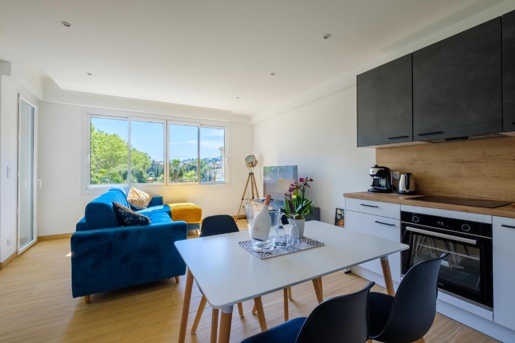 une cuisine et un salon avec une table et des chaises dans l'établissement LA GRANDE BLEUE, Magnifique T2 climatisé, proche de la mer, à Menton