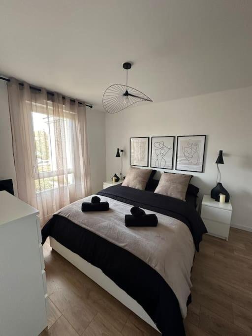 une chambre avec un grand lit avec deux serviettes dessus dans l'établissement Appartement Disney Val d'Europe, à Chessy