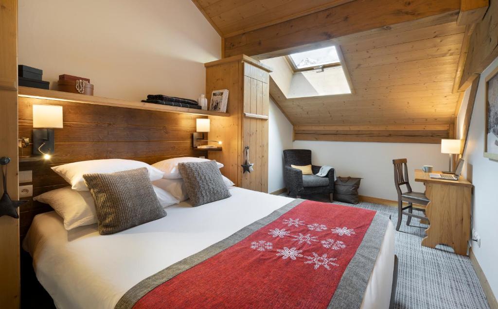 a bedroom with a large white bed with a red rug at Résidence Pierre & Vacances Premium Arc 1950 Le Village in Arc 1950