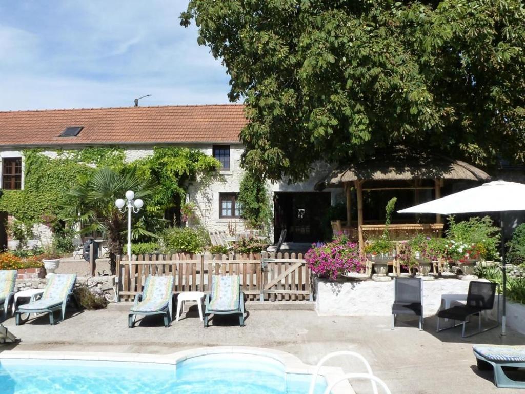 eine Terrasse mit Stühlen, einem Pool und einem Haus in der Unterkunft Charme au cœur des châteaux : Chambre d'hôtes avec Wifi - FR-1-590-329 in Tavers
