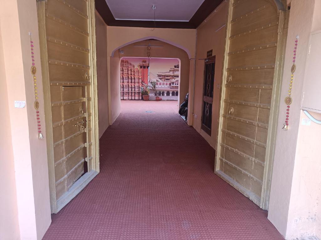 a hallway with wooden doors and a pink floor at Bhiwani Guest House in Jaipur