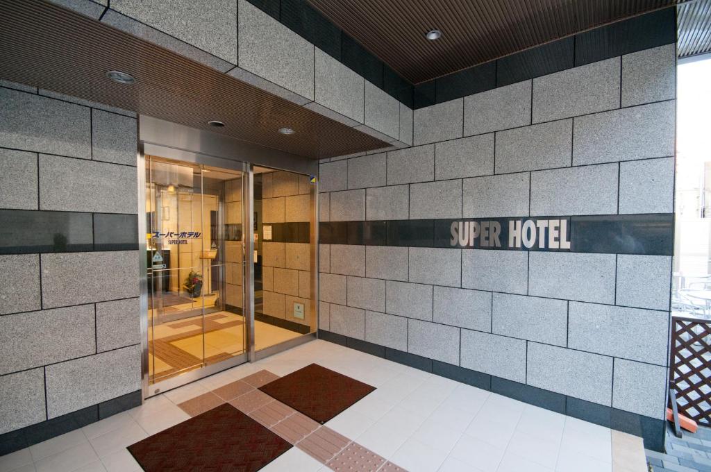 a lobby of a hotel with a sign that reads super hotel at Super Hotel Kokuraeki Minamiguchi in Kitakyushu