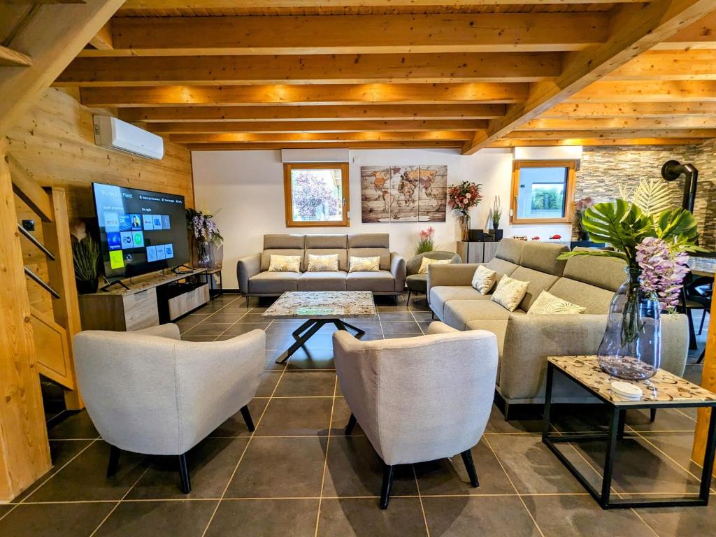 ein Wohnzimmer mit Sofas und Fernseher in der Unterkunft Chalet cosy avec sauna et spa dans le Massif des Vosges - FR-1-589-672 in Dommartin-lès-Remiremont