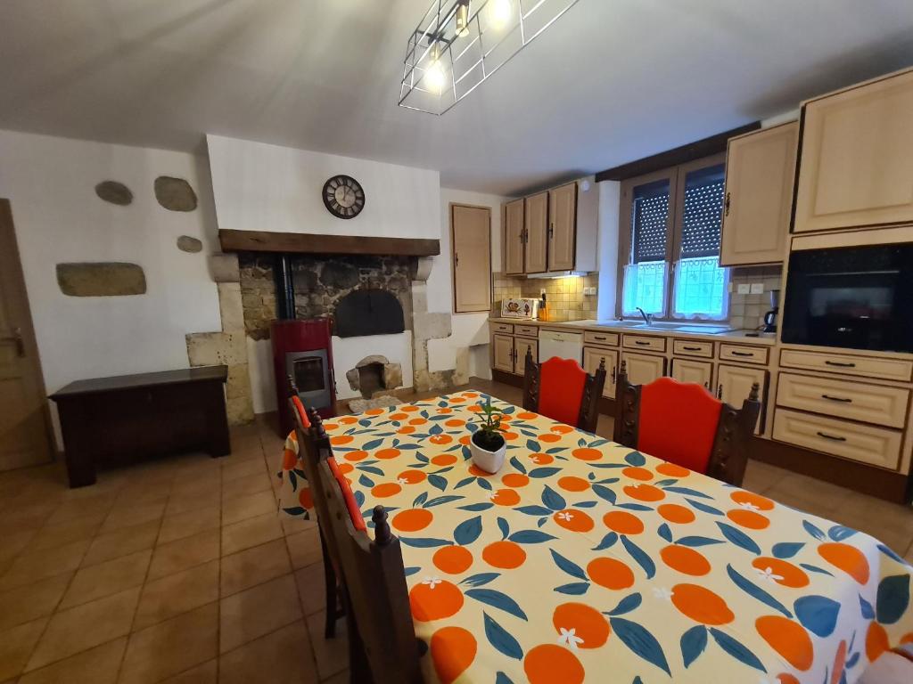 a kitchen with a table with orange and blue at Maison individuelle près de la Châtre, jardin privé, jacuzzi - FR-1-591-629 in La Berthenoux