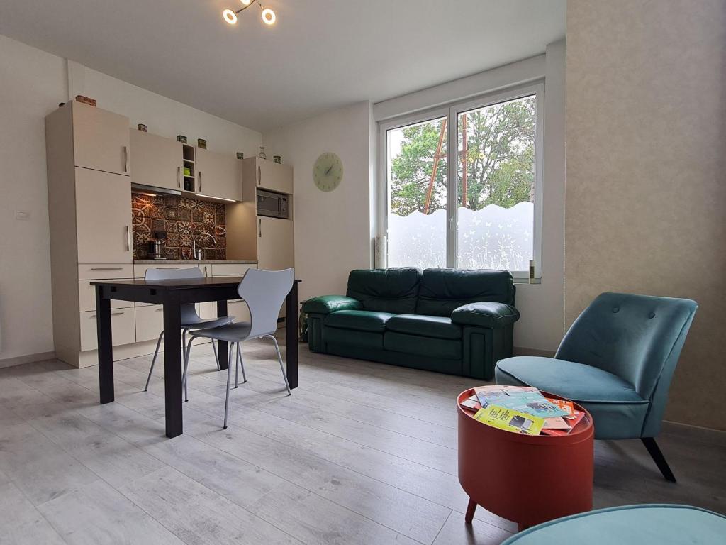 un salon avec une table, des chaises et un canapé dans l'établissement Charmant T2 lumineux à Nancy, quartier Haussonville - FR-1-584-334, à Nancy