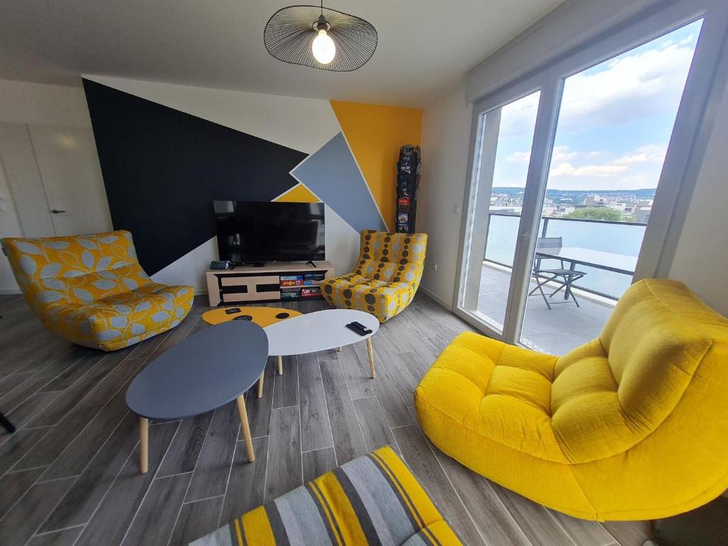 - un salon avec un canapé jaune, une table et des chaises dans l'établissement Appartement contemporain 3 chambres avec vue sur canal, parking et internet à Nancy - FR-1-584-343, à Nancy