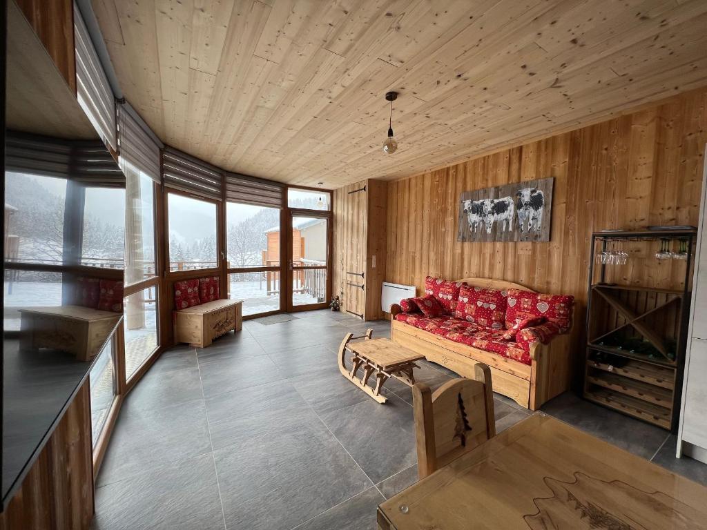 - un salon avec un canapé rouge et quelques fenêtres dans l'établissement Appartement moderne à La Bresse, 2 chambres, accès PMR - FR-1-589-687, à La Bresse