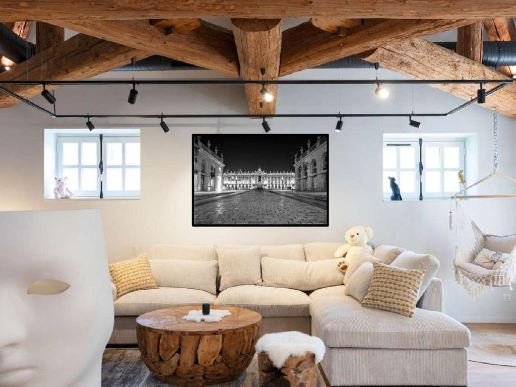 a living room with a couch and a table at Loft moderne au charme ancien, climatisé, près de la Place Stanislas - FR-1-584-352 in Nancy