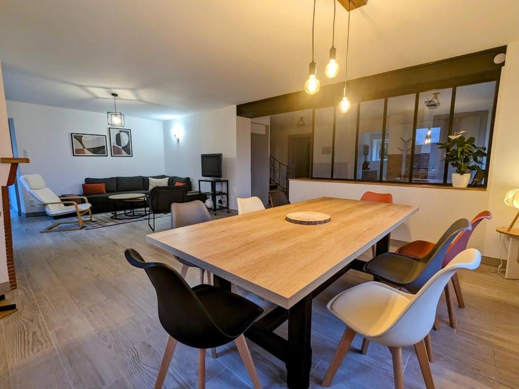 un salon avec une table et des chaises en bois dans l'établissement Maison rénovée près des Hautes Vosges, idéale pour activités nature - FR-1-589-696, à Saint-Nabord