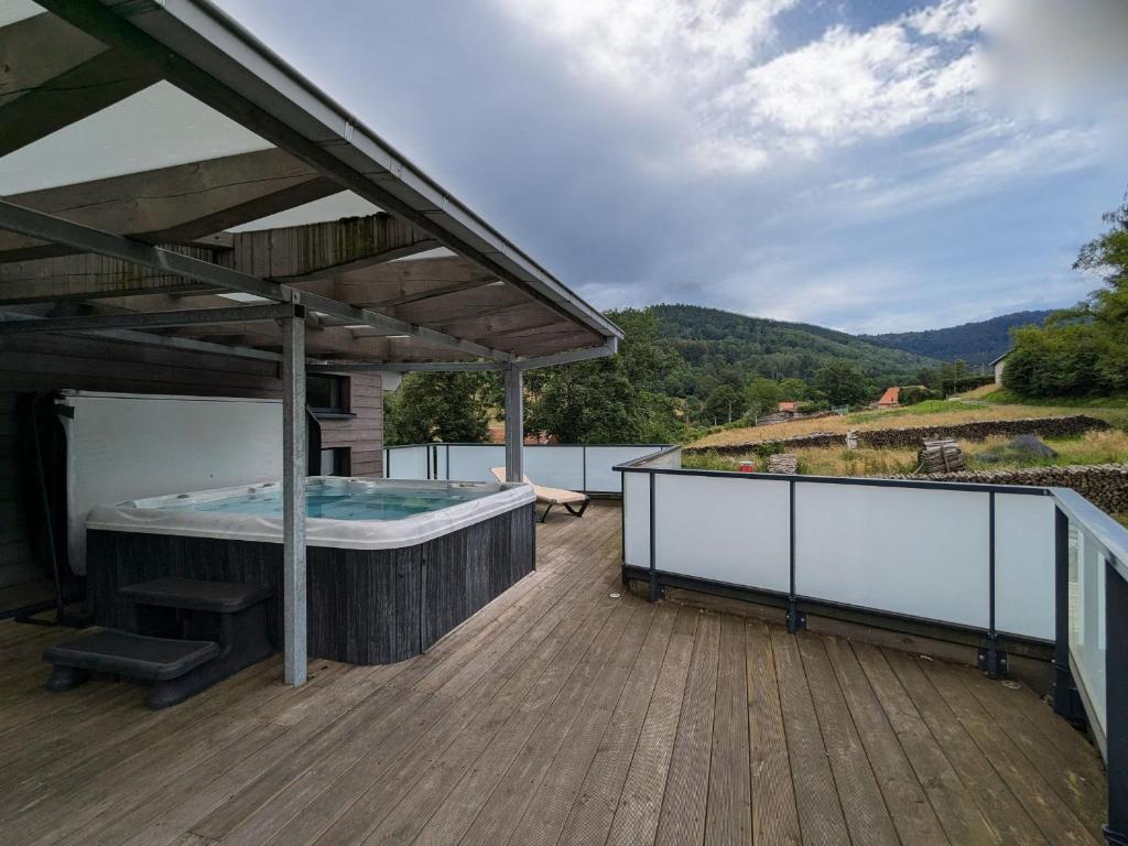 a hot tub on the deck of a house at Villa spacieuse avec spa et billard, WiFi, parking privé - FR-1-589-698 in Laveline