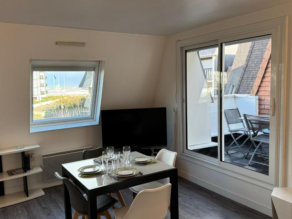 une salle à manger avec une table et des chaises et une fenêtre dans l'établissement Appartement 2 pièces avec balcon, parking, internet et animaux acceptés à Cabourg - FR-1-487-375, à Cabourg