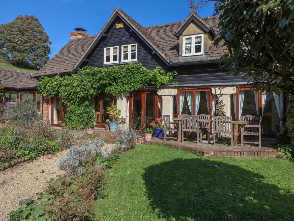a house with a patio and a yard at Highgrove Barn in Stroud