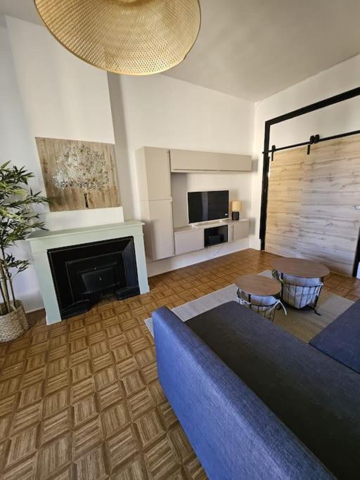un salon avec un canapé bleu et une cheminée dans l'établissement Appartement F2 à Villeurbanne, à Villeurbanne