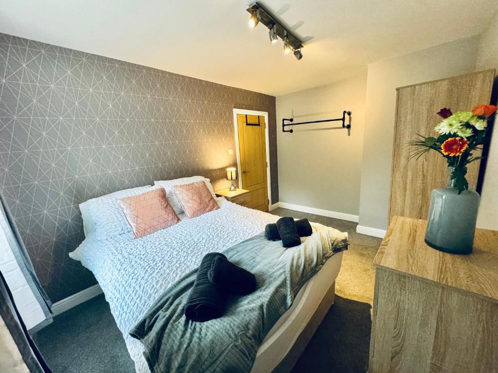 a bedroom with a bed and a vase of flowers at New Road Apartment - 2 Bedrooms - Sleeps 3 in Whitehaven