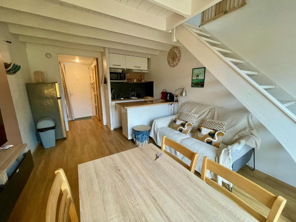 un salon avec un canapé et un escalier dans l'établissement Lumineux duplex plage à pied, à Pornichet