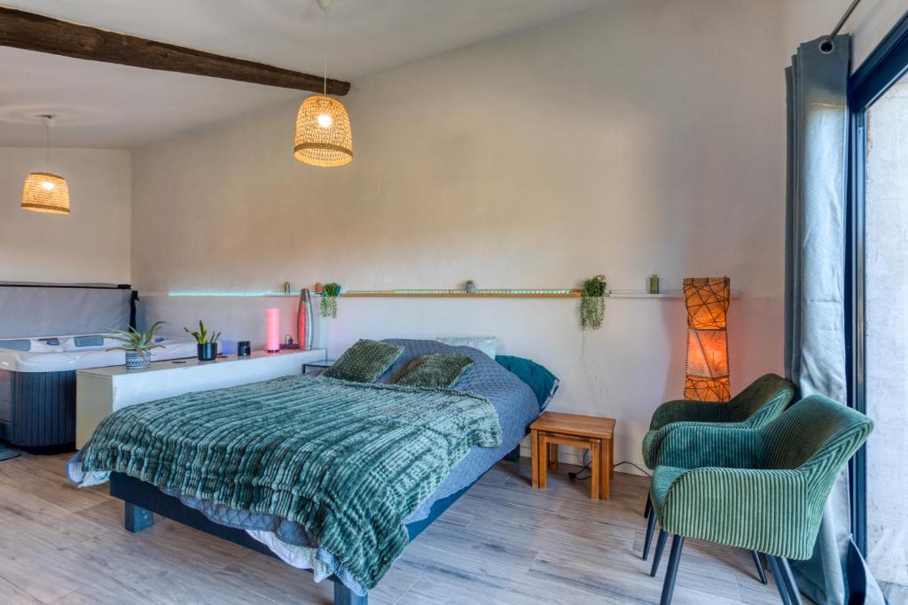 a bedroom with a bed and two chairs at Chambre spa privé Arles campagne in Arles