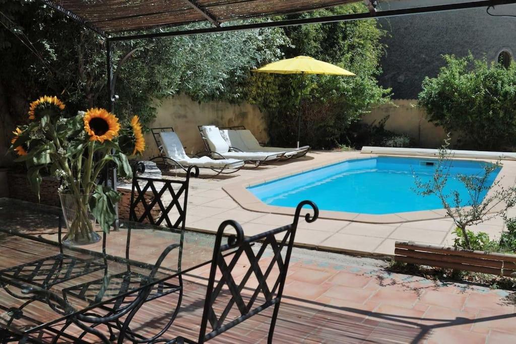- une piscine avec un vase de tournesols sur une terrasse dans l'établissement #Aillan Hervé #Maison avec piscine privée en provence, à Saint-Maurice-sur-Eygues