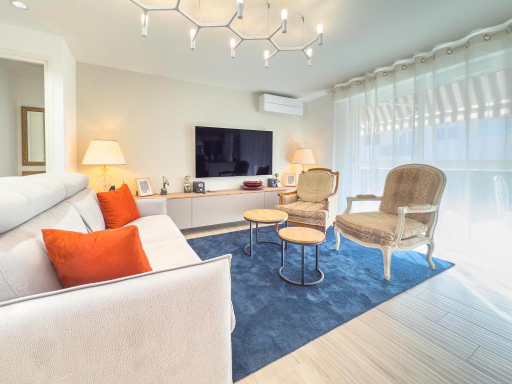 un salon avec un canapé, des chaises et une télévision dans l'établissement Le Marcellin by Winsome Destination, à Cannes