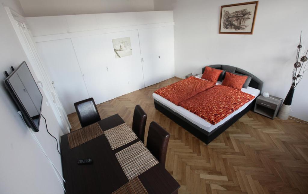 a bedroom with a bed and a table and a dining room at Carpe Diem Prague in Prague