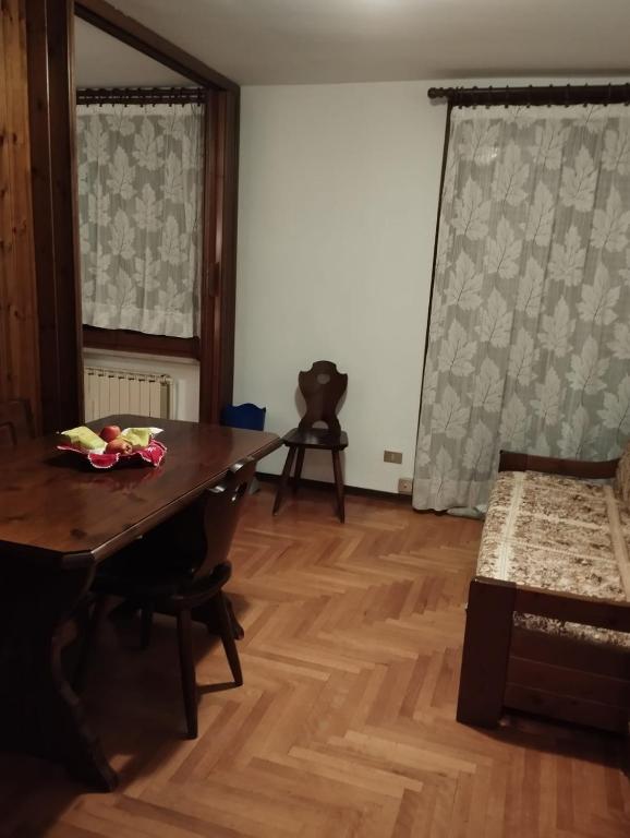 Zimmer mit Tisch und Bett in der Unterkunft Aleksander ski apartment in Breuil-Cervinia