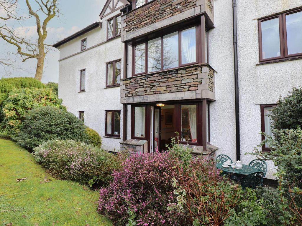a white house with a bench in front of it at Swallowdale in Ambleside