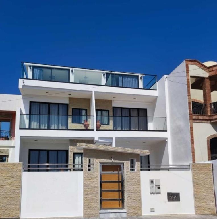 an apartment building with a balcony on top of it at Casa del mar in Agadir nʼ Aït Sa