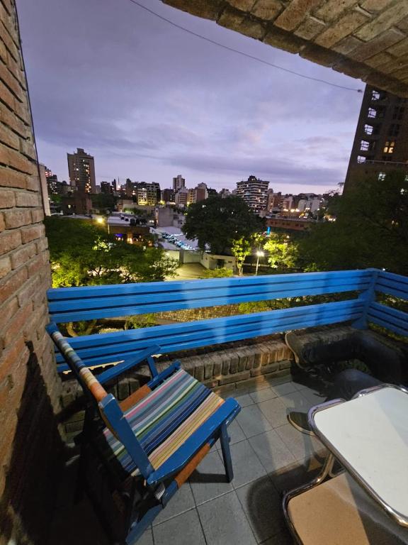 a blue bench sitting on a balcony overlooking a city at En la cañada cerca de todo in Córdoba