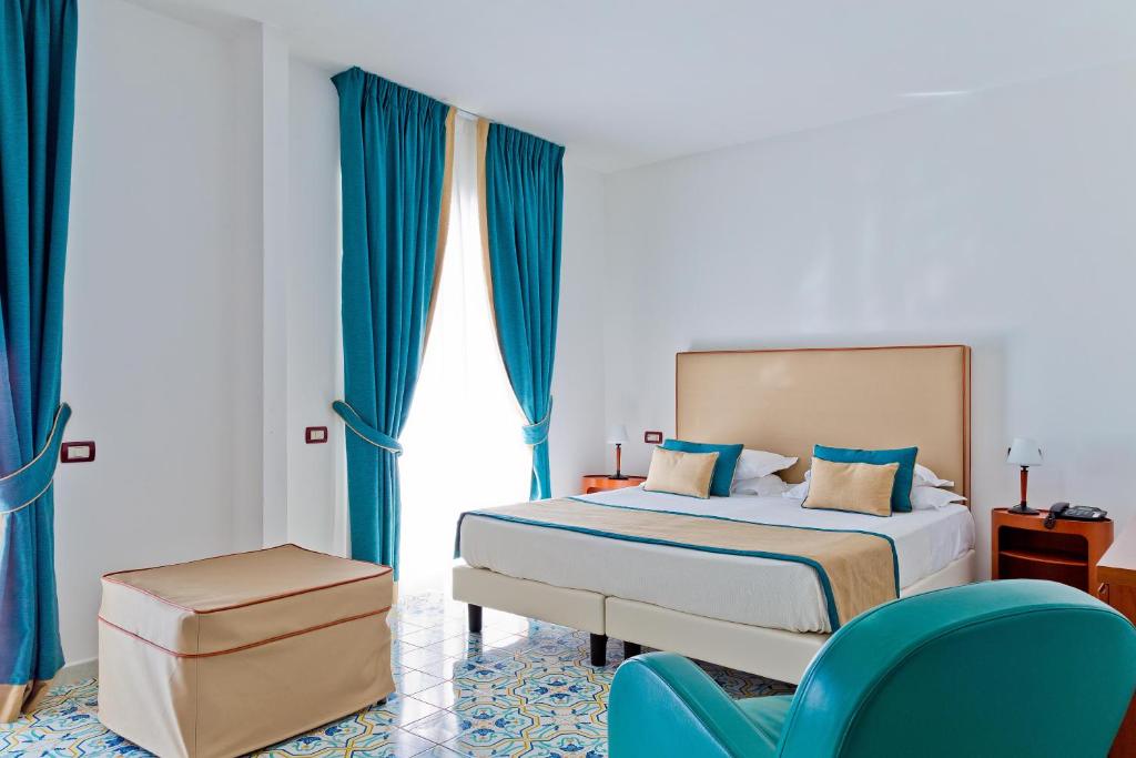 a bedroom with a bed and a dresser at Mediterranea Hotel & Convention Center in Salerno