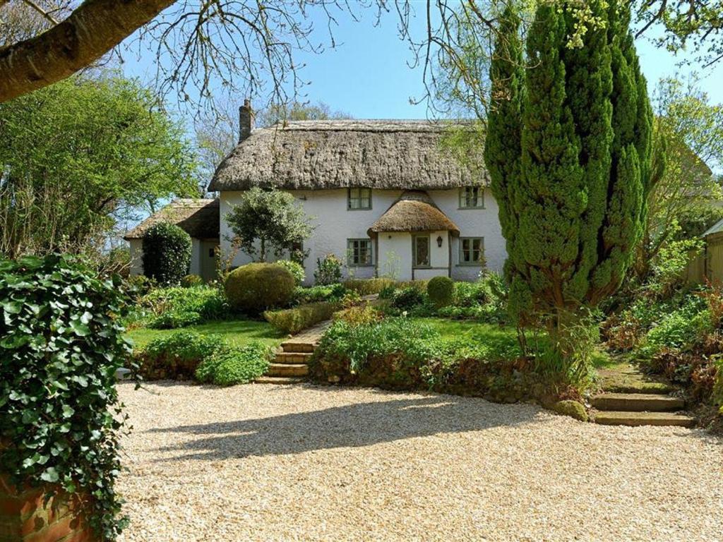 a large white house with a thatched roof at Church Cottage in Bridport
