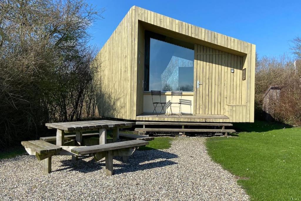 a small cabin with a picnic table and a window at Trek-in in IJsselstein