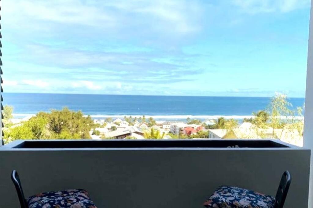 a view of the ocean from a balcony with two chairs at Appt Oceanne vue sur l'océan centre ville St Leu 5 min lagon in Saint-Leu