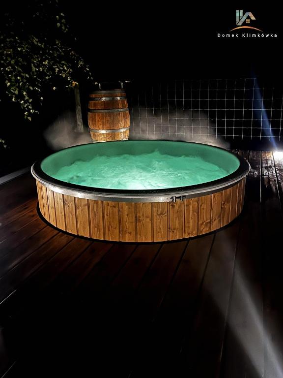 a jacuzzi tub on a wooden floor in a dark room at Domek Klimkówka in Klimkówka