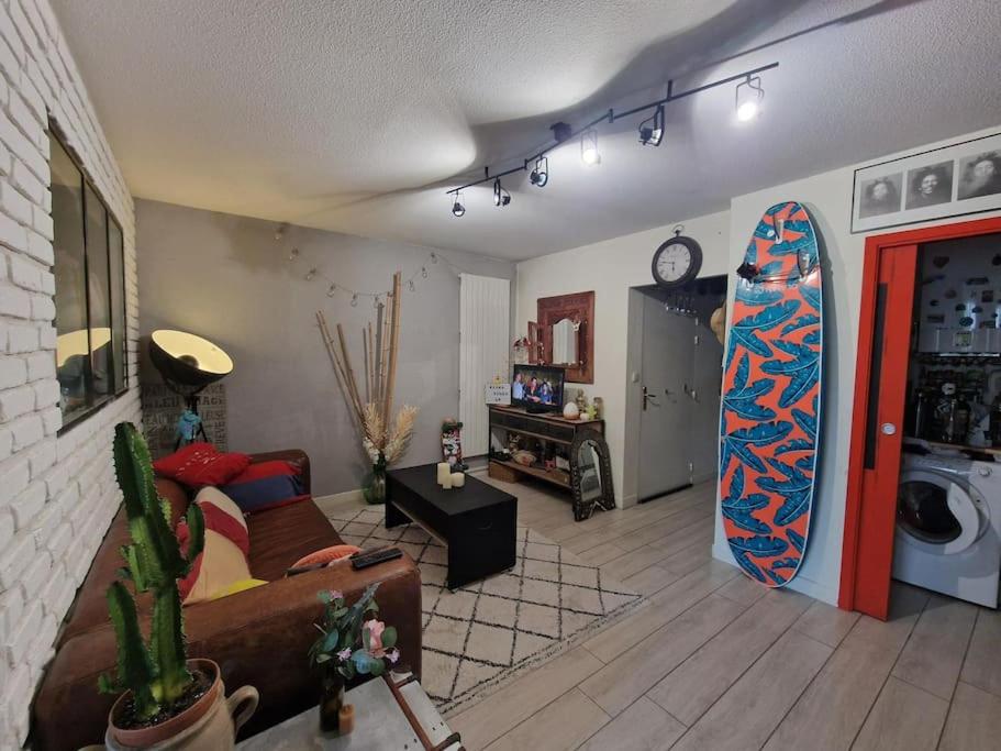 トゥールーズにあるAppartement bord de Garonne avec Parkingのリビングルーム(壁にサーフボード付)
