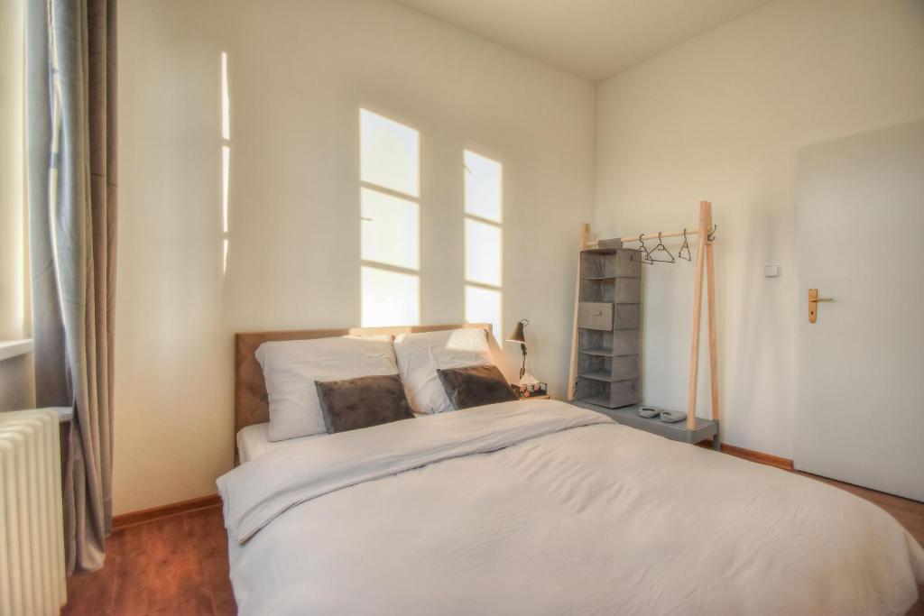 una camera da letto con un grande letto bianco e una finestra di Apartmán v centru Olomouce a Olomouc