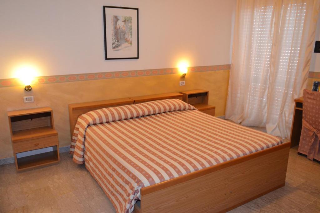 ヴィボ・ヴァレンツィアにあるAffittacamere Diavinのベッドルーム1室(ベッド1台、ナイトスタンド2台付)