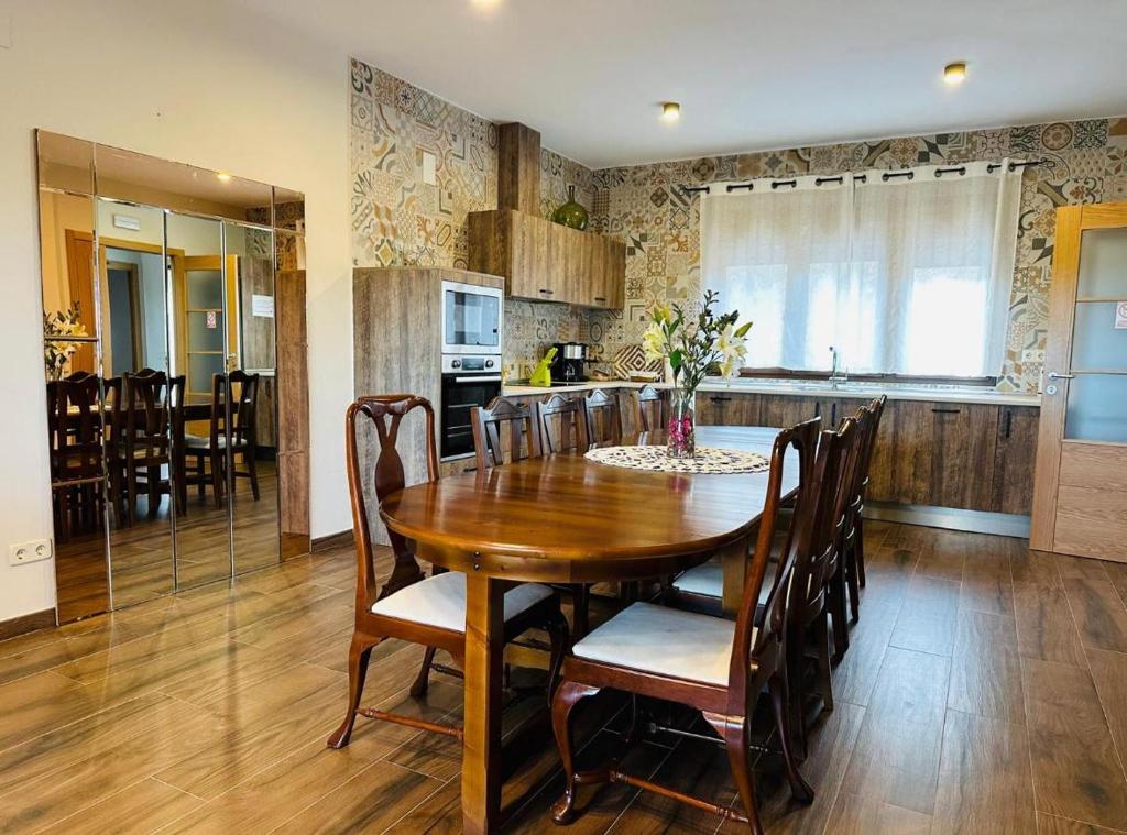 a kitchen and dining room with a wooden table and chairs at Casa Rural Cristina in Morcuera