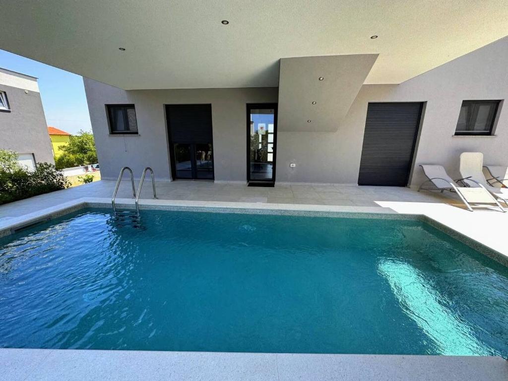 a swimming pool in front of a house at House Dusa in Banjole