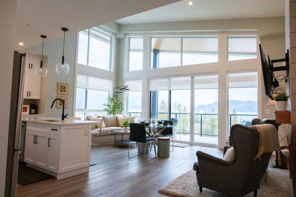 eine Küche und ein Wohnzimmer mit einem großen Fenster in der Unterkunft The Luna, New Penthouse w Patio, Lake and Mtn Views in Harrison Hot Springs