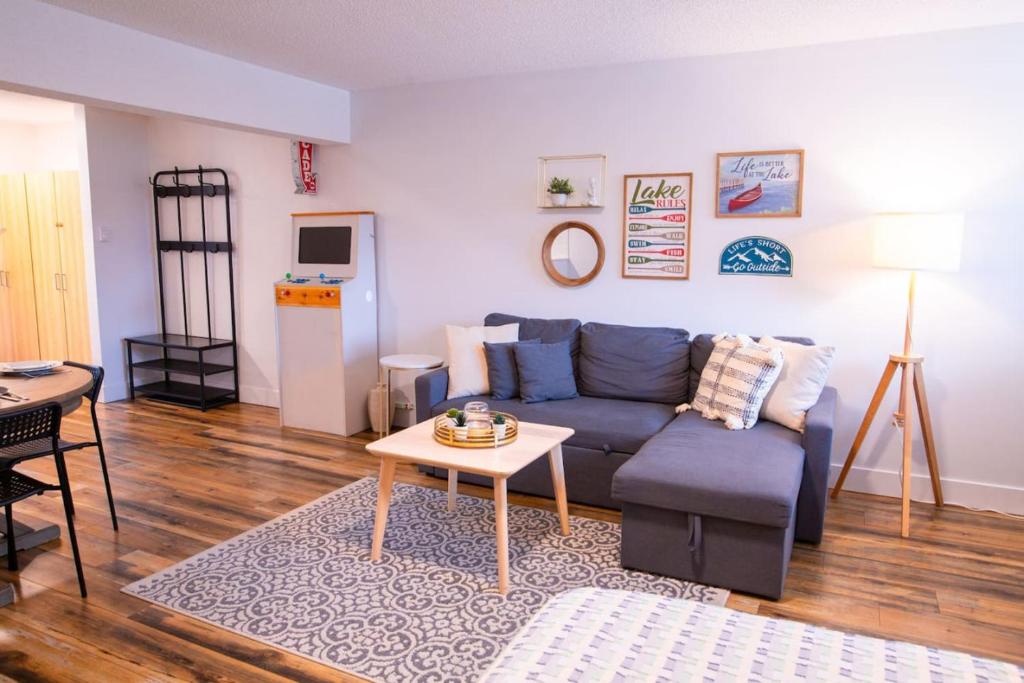 a living room with a blue couch and a table at Harrison Lake Retreat, Studio Suite in Harrison Hot Springs
