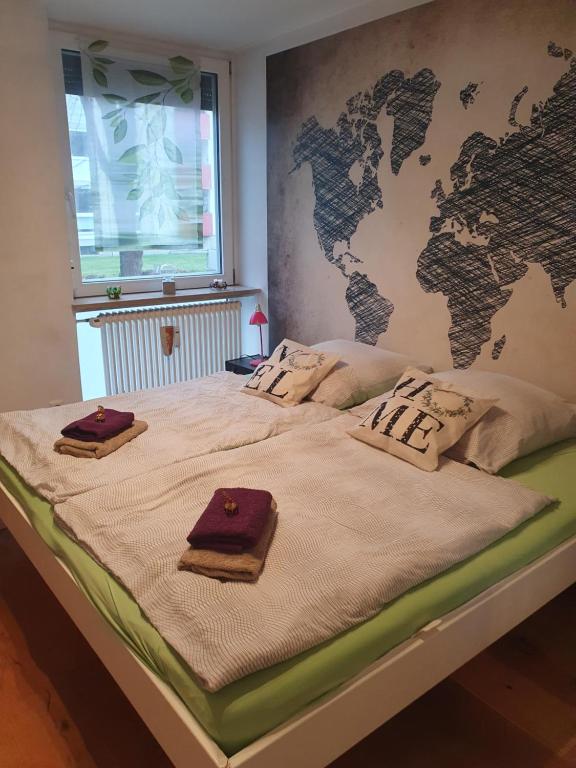 a bed with a map of the world on the wall at Ferienwohnung Apartment modern, bis 4 Personen, Altstadt fußläufig in Landshut