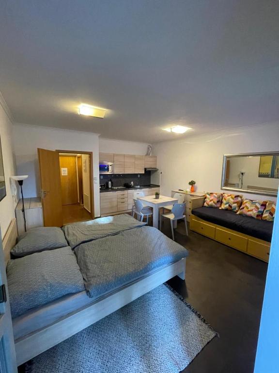 a bedroom with two beds and a table and a kitchen at Apartman Harrachov - Resident in Harrachov