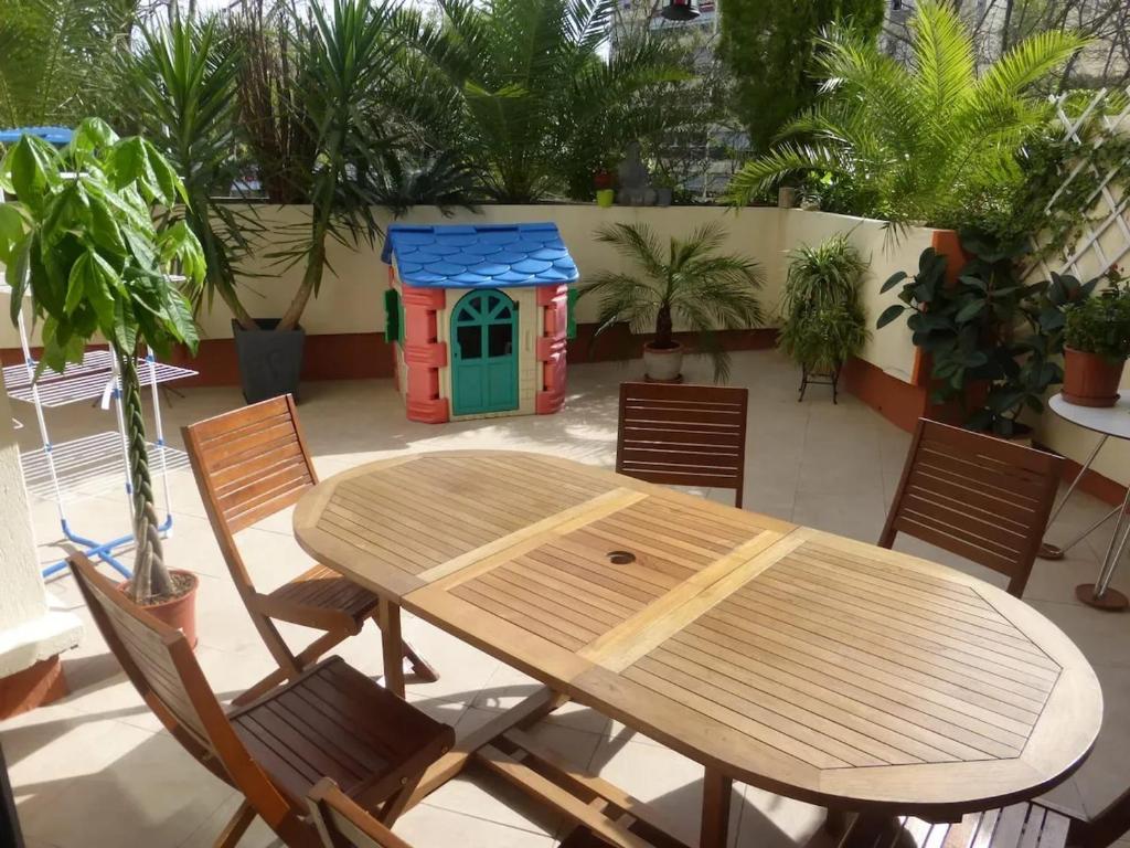 un tavolo e sedie in legno e una casetta per i giochi di Appartement spacieux à Montpellier de 95 m² a Montpellier