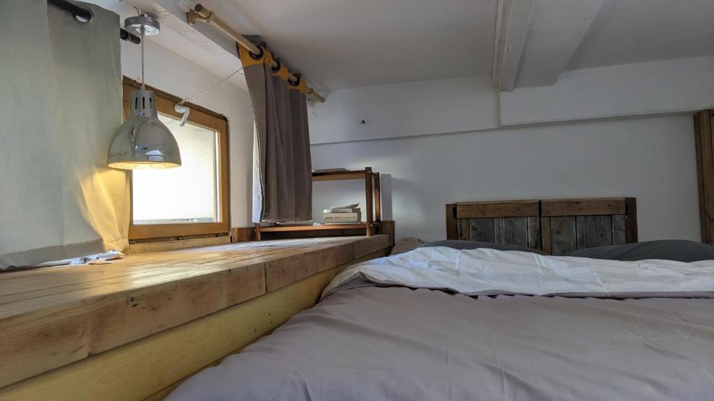 une chambre avec un lit, un miroir et une fenêtre dans l'établissement Loft Marseille, à Marseille