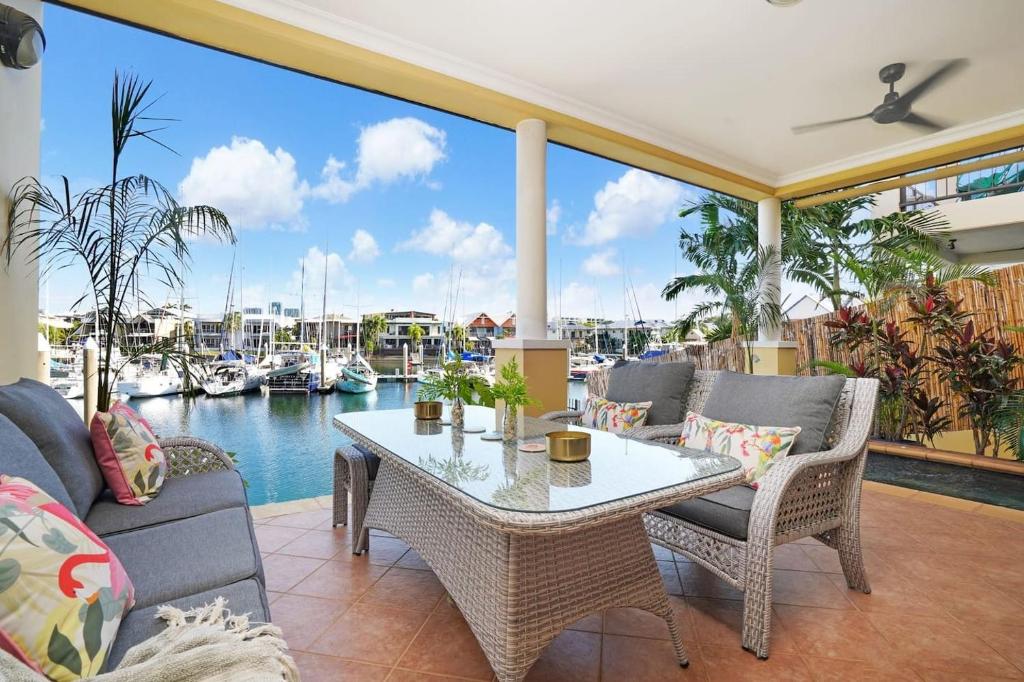 a patio with a table and chairs and a marina at Villa Utopia On The Marina 3 Bed, 3 Bath in Stuart Park