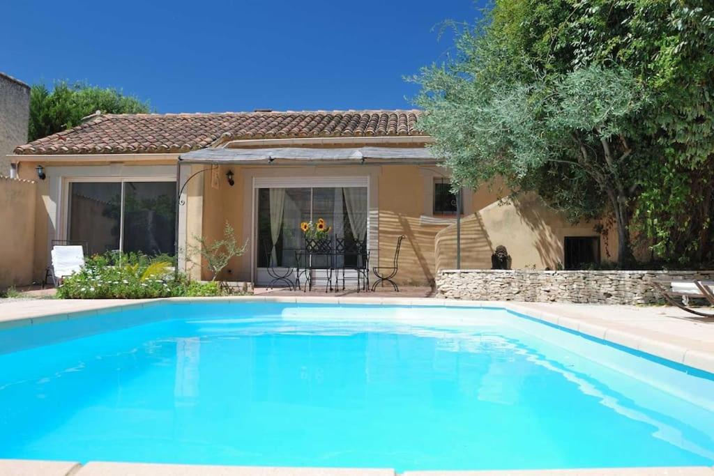 une grande piscine bleue devant une maison dans l'établissement Aillan Hervé Maison avec piscine privée, à Saint-Maurice-sur-Eygues