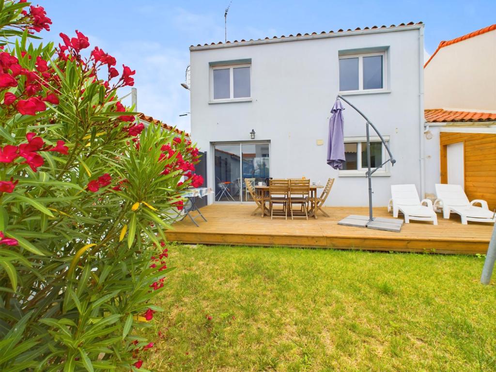 une maison dotée d'une terrasse en bois avec une table et des chaises dans l'établissement À 15min à pied de la plage, maison pour 6, à Les Sables-dʼOlonne